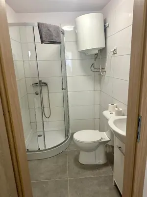 a bathroom with a shower and a toilet and a sink at Wolnica Apartament 2 in Kraków