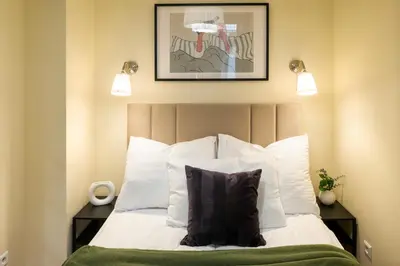 a bedroom with a bed with white sheets and pillows at Discover Krakow Apartments - 8 Rakowicka St - Stylish Balcony Apartment with Netflix in Kraków