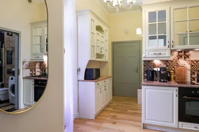 a kitchen with white cabinets and a mirror at Discover Krakow Apartments - 8 Rakowicka St - Stylish Balcony Apartment with Netflix in Kraków