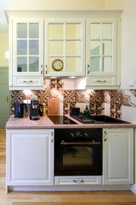 a kitchen with white cabinets and a black microwave at Discover Krakow Apartments - 8 Rakowicka St - Stylish Balcony Apartment with Netflix in Kraków