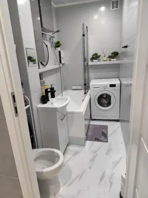 a white bathroom with a toilet and a washing machine at Albertyńskie House in Kraków