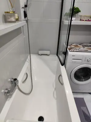a bathroom with a washing machine and a sink at Albertyńskie House in Kraków