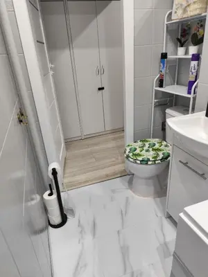 a white bathroom with a toilet with a flower seat at Albertyńskie House in Kraków