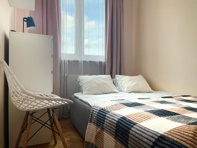 a bedroom with a bed and a chair and a window at Cozy Two Bedrooms Apartment in Cracow City in Kraków