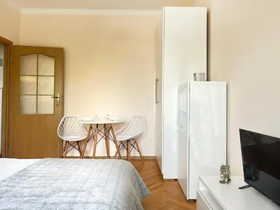 a bedroom with a bed and a table with chairs at Cozy Two Bedrooms Apartment in Cracow City in Kraków