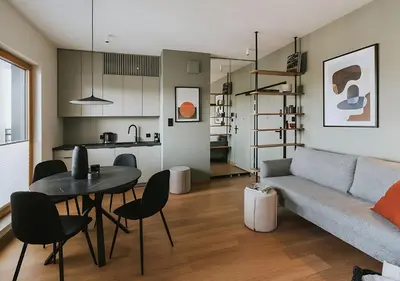 a living room with a couch and a table and a kitchen at Rakowicka Modern Apartment with Air Conditioning in City Center by Noclegi Renters in Kraków