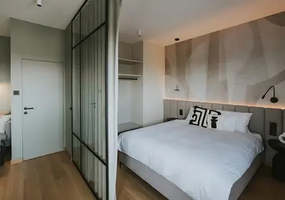a bedroom with a large white bed and a mirror at Rakowicka Modern Apartment with Air Conditioning in City Center by Noclegi Renters in Kraków