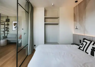 a bedroom with a large white bed and a staircase at Rakowicka Modern Apartment with Air Conditioning in City Center by Noclegi Renters in Kraków