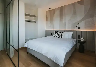 a bedroom with a large white bed with black and white pillows at Rakowicka Modern Apartment with Air Conditioning in City Center by Noclegi Renters in Kraków