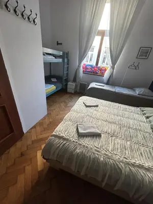 a large bed in a room with a wooden floor at CityGate Kraków in Kraków