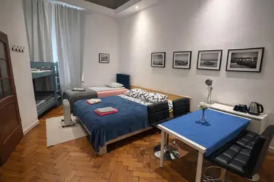 a room with two beds and a table and a window at CityGate Kraków in Kraków