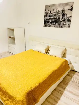 an orange chair in a room with a mirror at CityGate Kraków in Kraków