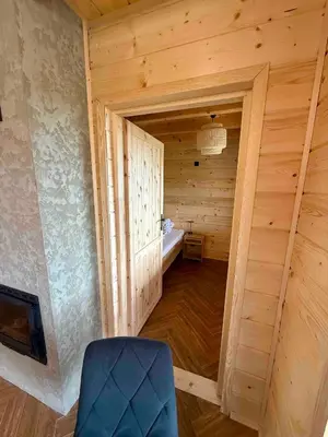 an empty room with a blue chair in a wooden room at Slow Mountains in Wola Piskulina