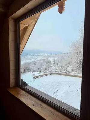 a window with a view of a snow covered roof at Slow Mountains in Wola Piskulina
