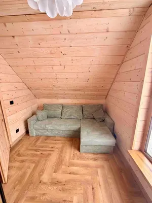 a room with a couch in the middle of a attic at Slow Mountains in Wola Piskulina