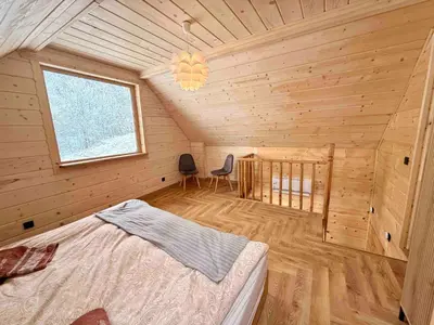 a bedroom with a bed in a wooden cabin at Slow Mountains in Wola Piskulina