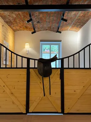a loft with a black chair in a room with wooden floors at Villa Pippi in Tokarnia