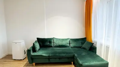 a green couch in a room with a window at Kraków Cozy Spot Center in Kraków