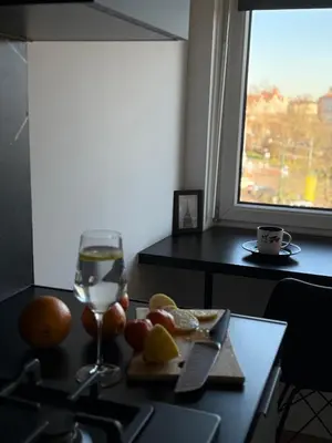 a glass of wine and a plate of fruit on a table at Kraków Cozy Spot Center in Kraków