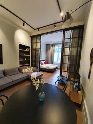 a living room with a table and a couch at Stradom Apartments by Noah in Kraków