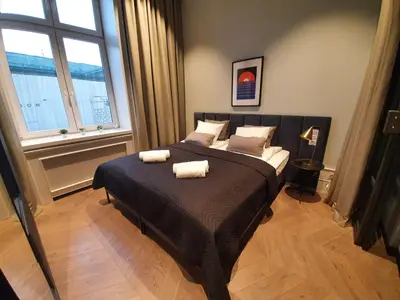 a bedroom with a large bed with two towels on it at Stradom Apartments by Noah in Kraków