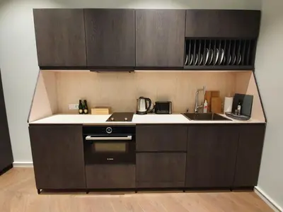 a kitchen with brown cabinets and a sink and a stove at Stradom Apartments by Noah in Kraków