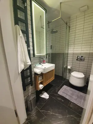 a bathroom with a sink and a toilet and a mirror at Stradom Apartments by Noah in Kraków