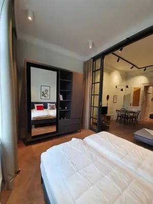 a bedroom with a large white bed with a large mirror at Stradom Apartments by Noah in Kraków