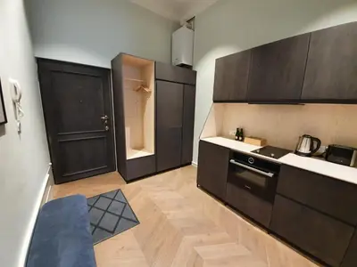 a kitchen with black cabinets and a counter top at Stradom Apartments by Noah in Kraków