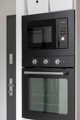 a microwave sitting on top of a oven at Functional Apartment with Parking in Cracow by Noclegi Renters in Kraków