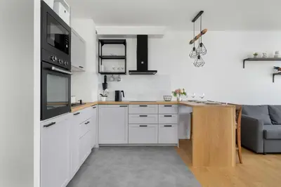 a kitchen with white cabinets and a counter top at Functional Apartment with Parking in Cracow by Noclegi Renters in Kraków