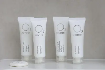 a group of four white bottles oforative cosmetics on a counter at Functional Apartment with Parking in Cracow by Noclegi Renters in Kraków