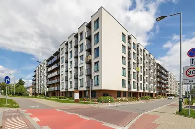 a large white building on a city street at Functional Apartment with Parking in Cracow by Noclegi Renters in Kraków