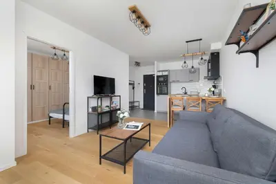 a living room with a couch and a table at Functional Apartment with Parking in Cracow by Noclegi Renters in Kraków
