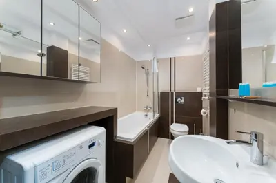 a bathroom with a washing machine and a sink at Cracow Home Harmony Apartment by BookingHost in Kraków