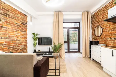 a living room with a couch and a brick wall at Charming Kazimierz Studio near Wawel in Kraków