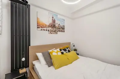 a bedroom with a bed with yellow pillows at Charming Kazimierz Studio near Wawel in Kraków