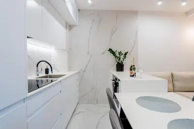 a white kitchen with a sink and a counter at K16 Apartments in Kraków