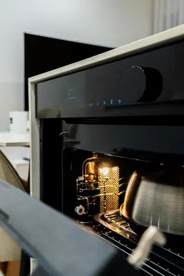 a toaster oven with its door open with a cake inside at K16 Apartments in Kraków