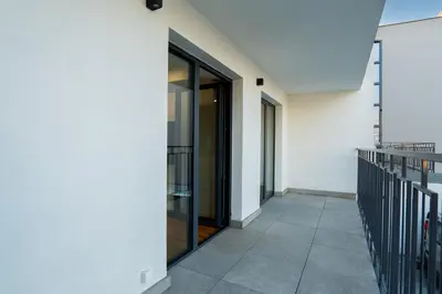 a hallway of a white building with glass doors at K16 Apartments in Kraków