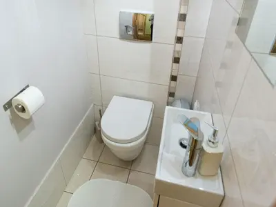 a small bathroom with a toilet and a sink at 5 Bedroom Family Apartment in Kraków
