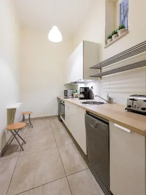 a kitchen with white cabinets and a counter top at 5 Bedroom Family Apartment in Kraków