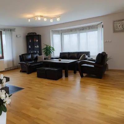 a living room with leather furniture and a wooden floor at Dworek pod Jeżową Wodą in Młyńczyska