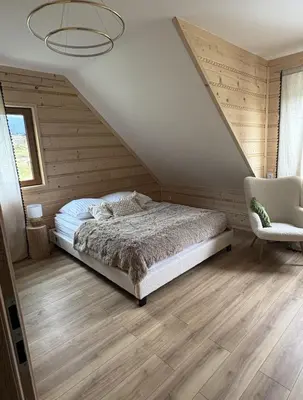 a bedroom with a bed and a chair at Zawojenka in Zawoja