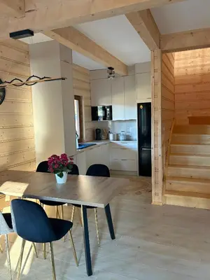 a kitchen and dining room with a wooden table and chairs at Zawojenka in Zawoja