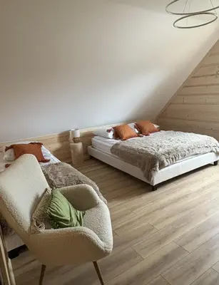 a bedroom with two beds and a chair in it at Zawojenka in Zawoja