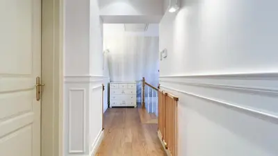 a hallway with white walls and a wooden floor at Golden Villas - Elegant Family Villa with Garden near Krakow in Węgrzce