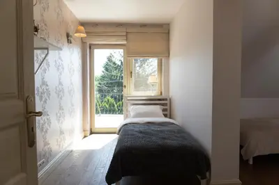 a bedroom with a bed and a large window at Golden Villas - Elegant Family Villa with Garden near Krakow in Węgrzce