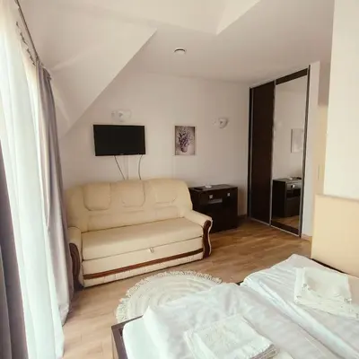 a living room with a couch and a tv at Gościniec Tenczyn in Tenczyn