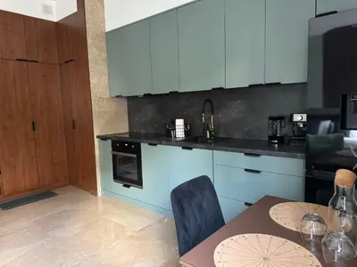 a kitchen with blue cabinets and a dining table at Apartament KRAKÓW CENTRUM Smoleńsk 33 in Kraków